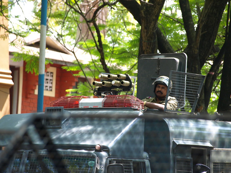 Może być zdjęciem przedstawiającym indyjskiego policjanta, który porusza się opancerzonym pojazdem