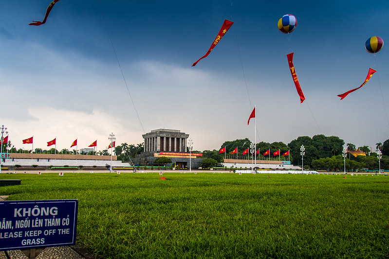 Może być zdjęciem przedstawiającym mauzoleum wietnamskiego rewolucjonisty Ho Chi Minha, na zdjęciu wyróżnia się zielona trawa, drzewa i czyste niebo