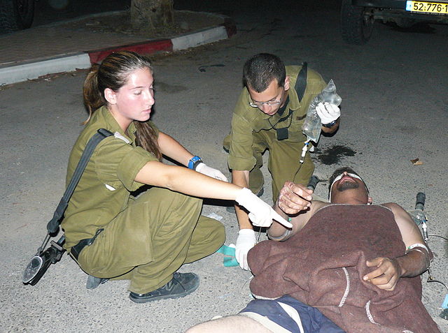 Może być zdjęciem przedstawiającym żołnierzy izraelskich sił zbrojnych, którzy pomagają poszkodowanemu mężczyźnie