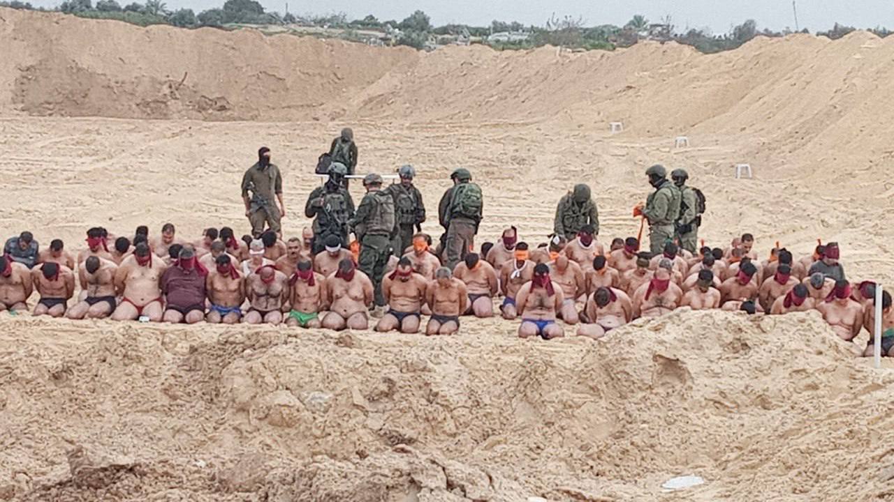Może być zdjęciem przedstawiającym półnagich jeńców w piaszczystym dole, wśród nich izraelscy żołnierze