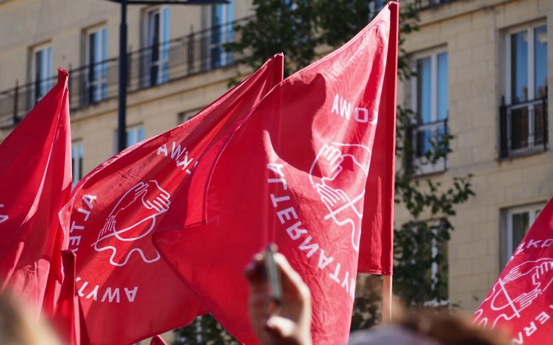 Może być zdjęciem przedstawiającym czerwone flagi z logiem Związkowej Alternatywy, polskiego związku zawodowego