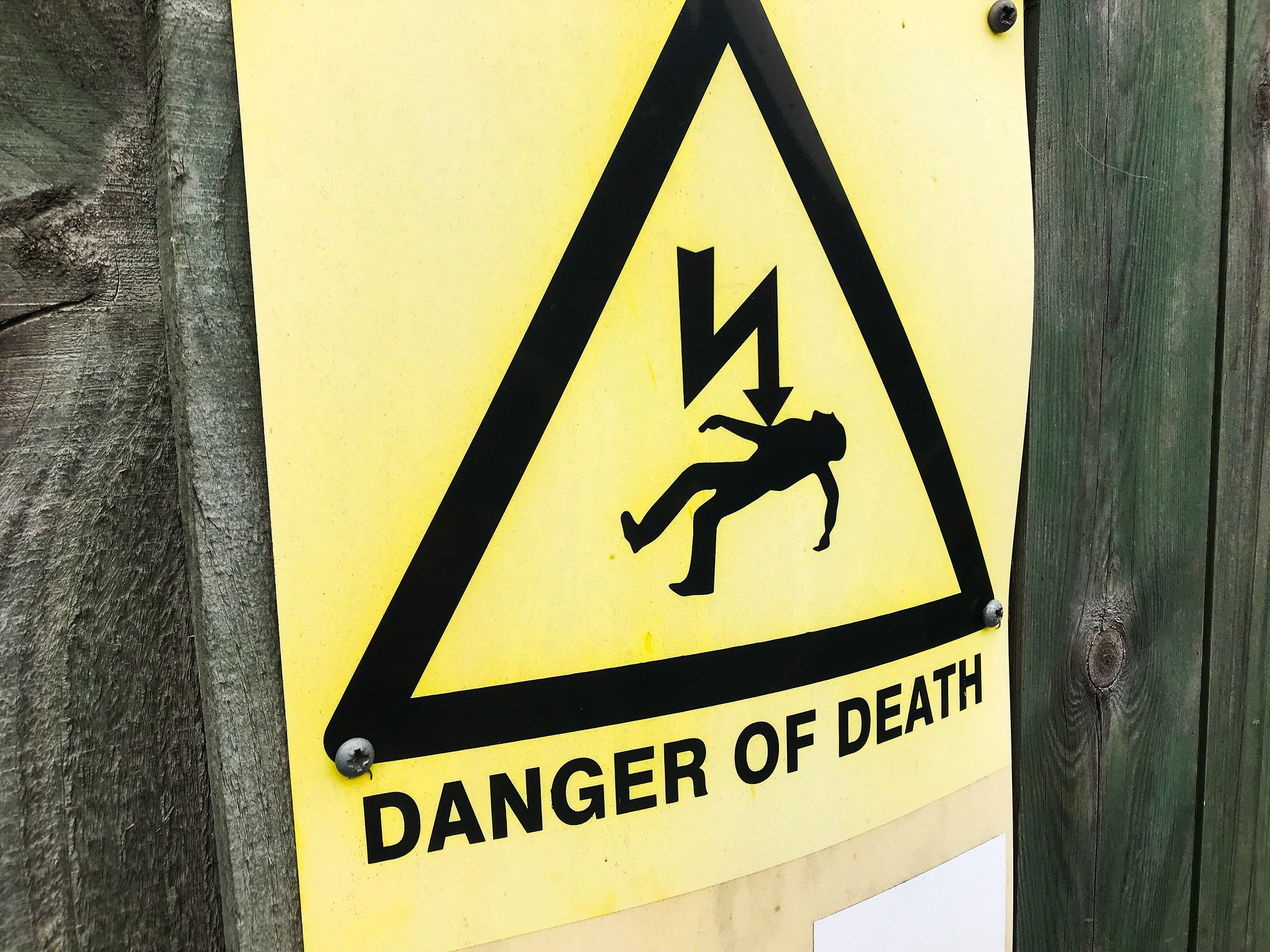 Na zdjęciu jest pokazana żółta tabliczka z napisem ostrzegającym przed niebezpieczeństwem
