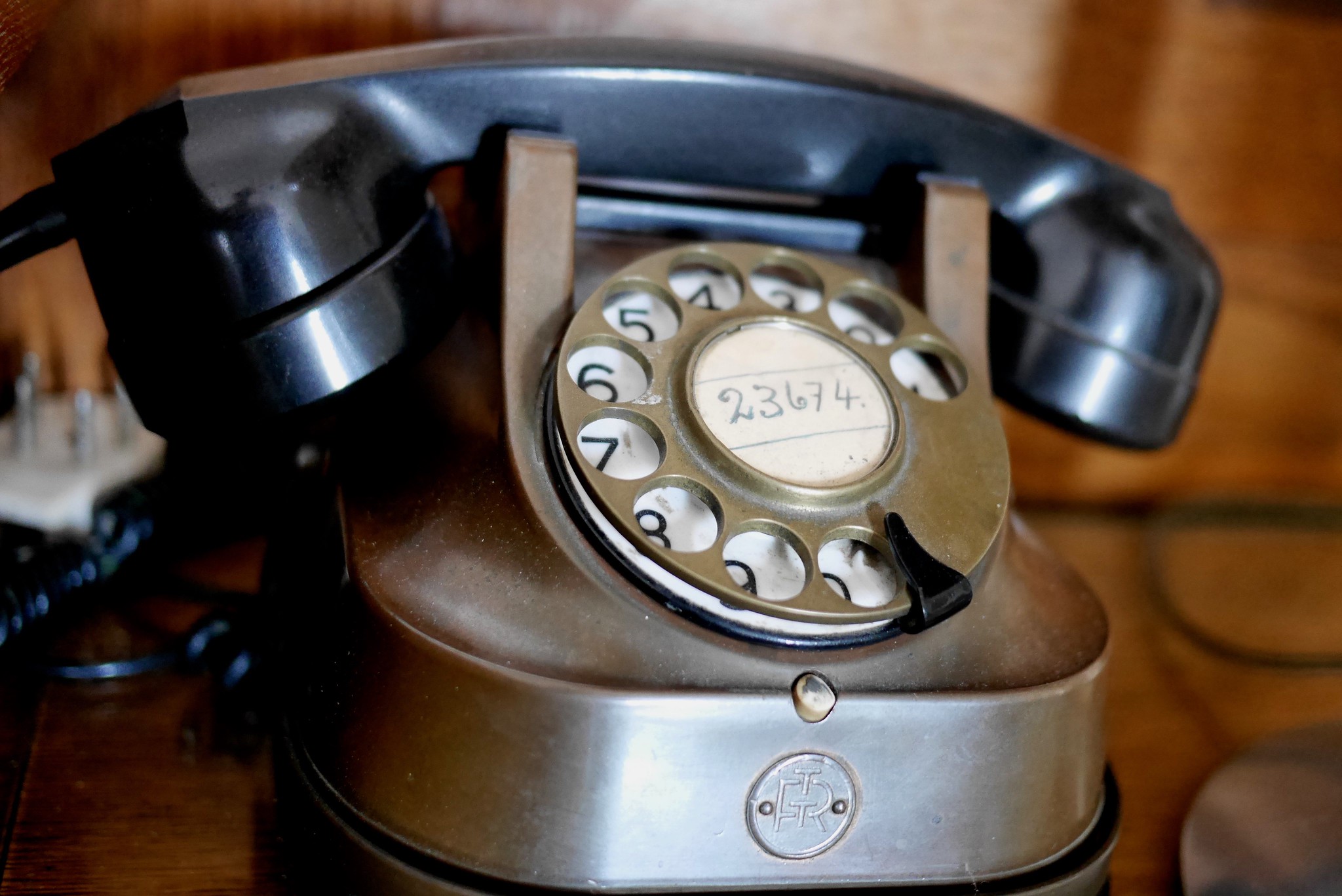 Zdjęcie przedstawia stary telefon stacjonarny w kolorze czarnym