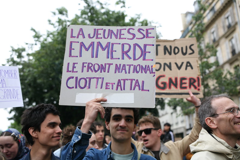 Zdjęcie przedstawia francuzów, którzy trzymają tablice z napisami w języku francuskim